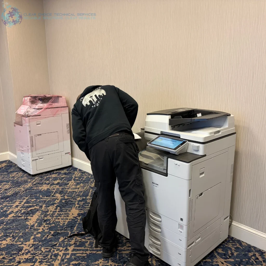 A technician installing a high-volume multi-function printer for an on-site copier rental in Dallas.